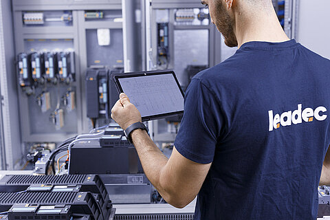 Leadec employee with a tablet checking switch cabinet.